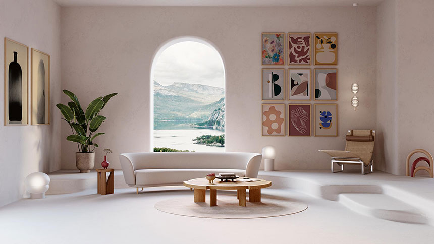 Art is beauty and beauty fosters happiness. Lifestyle image of a living room with an arched window and view of a lake, along with a gallery of art prints, a curved white sofa and a wooden round coffee table. Image: Nest.co.uk.