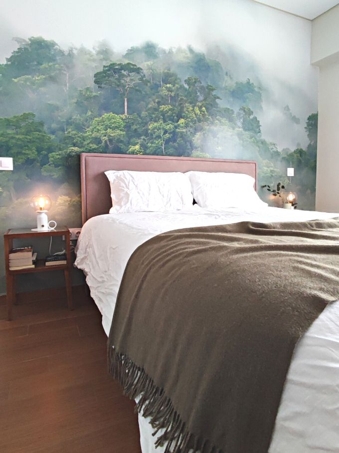 Contemporary bedroom with an organic vibe and a wallpaper mural of a forest designed by Velvet Karatzas.