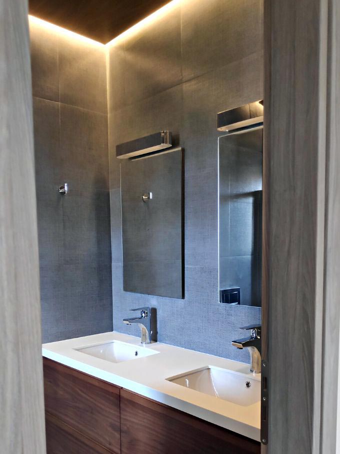 A double sink custom-made washbasin and a walnut paneled ceiling designed by Velvet Karatzas.
