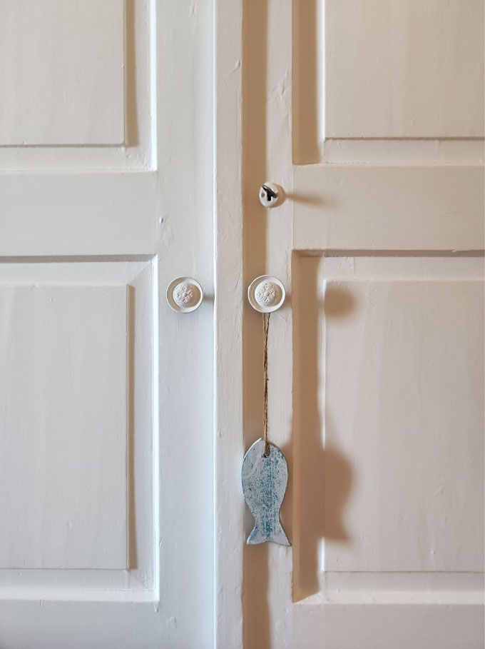 Detail of a vintage white door and its pulls.