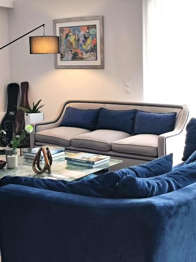 A contemporary sitting room with a blue velvet sofa, designed by Velvet Karatzas.