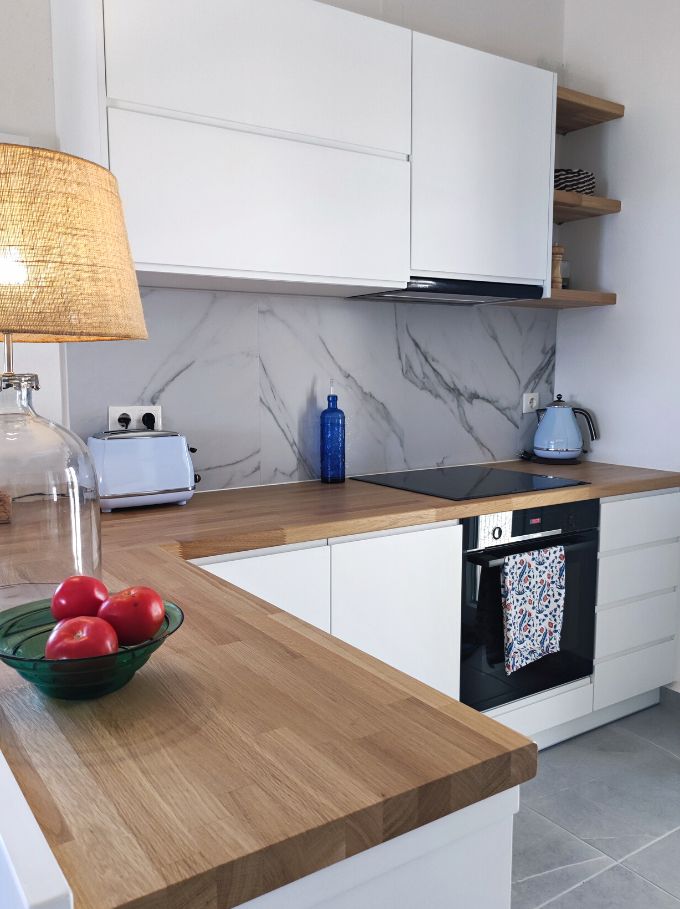 A white kitchen with an oak countertop designed by Velvet Karatzas. Image by Velvet Karatzas.